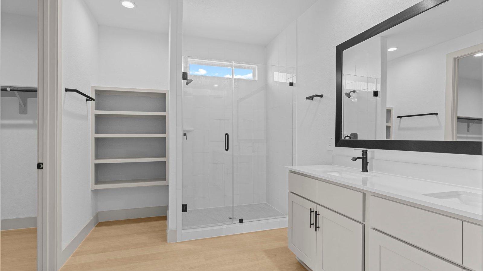 primary bathroom with two sinks and glass framed shower