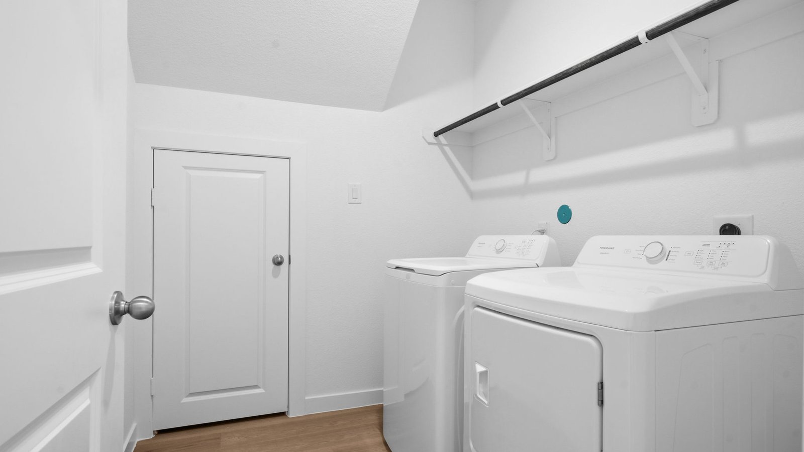 A laundry room featuring a washer and dryer, neatly arranged with ample space for laundry tasks and storage.