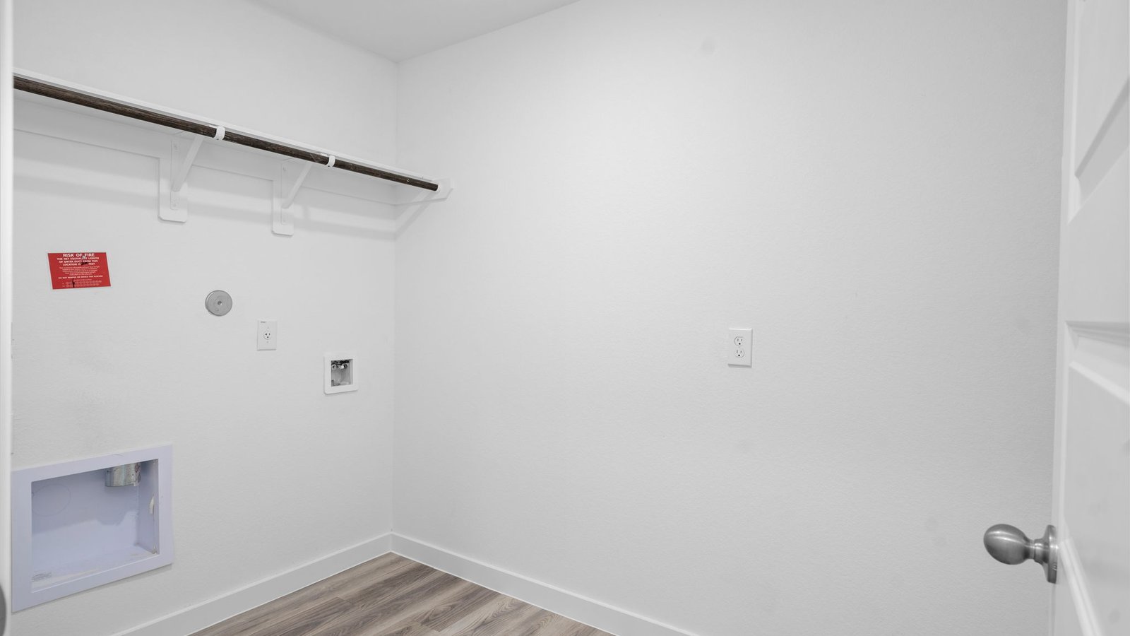 Spacious laundry room with washer and dryer connections, hanging rod, and vinyl wood flooring