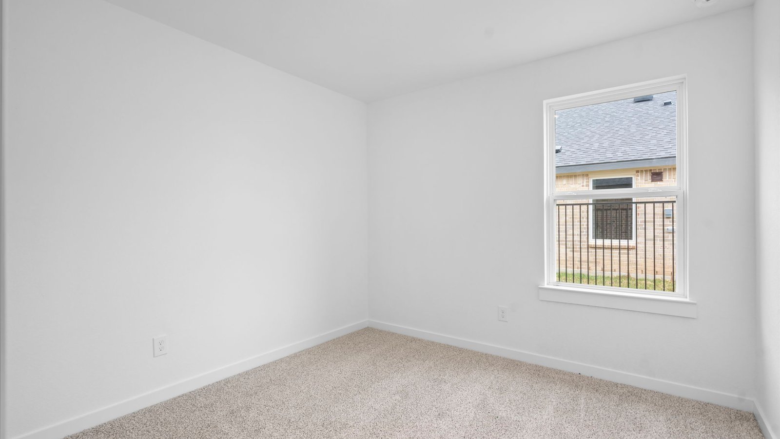 Comfortable guest bedroom featuring neutral-toned walls, carpeted flooring, and a separate closet.