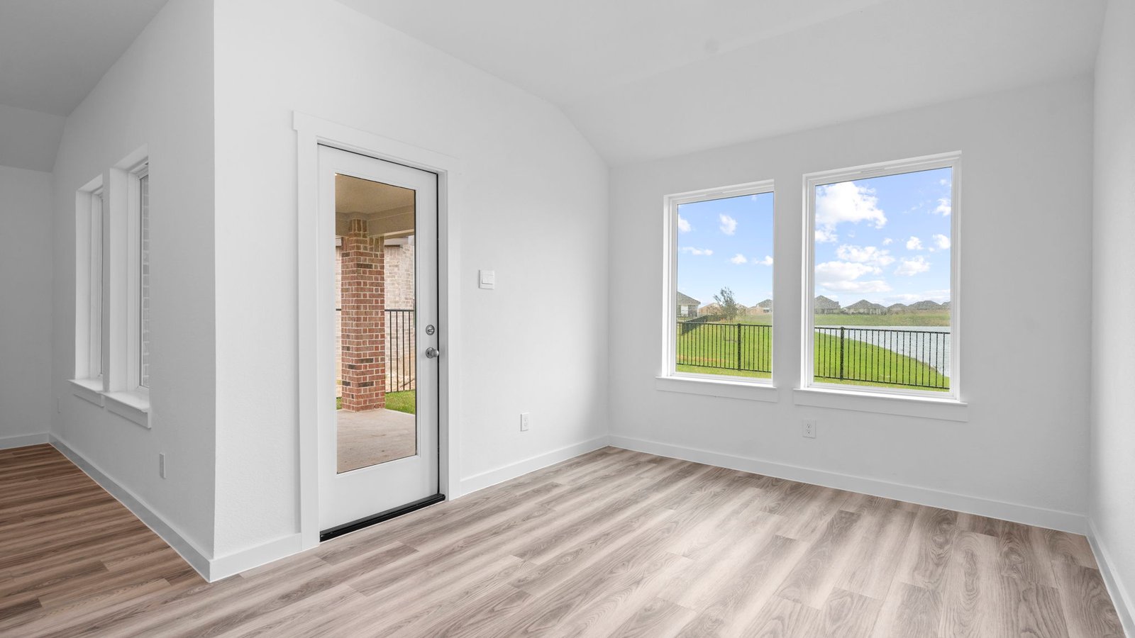 Formal dining room with large windows, wood floors, and view of the backyard.