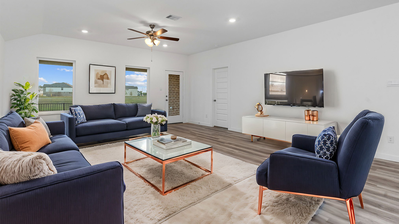 A well-organized living room that includes a kitchen and dining area, creating a warm and welcoming environment for gatherings.