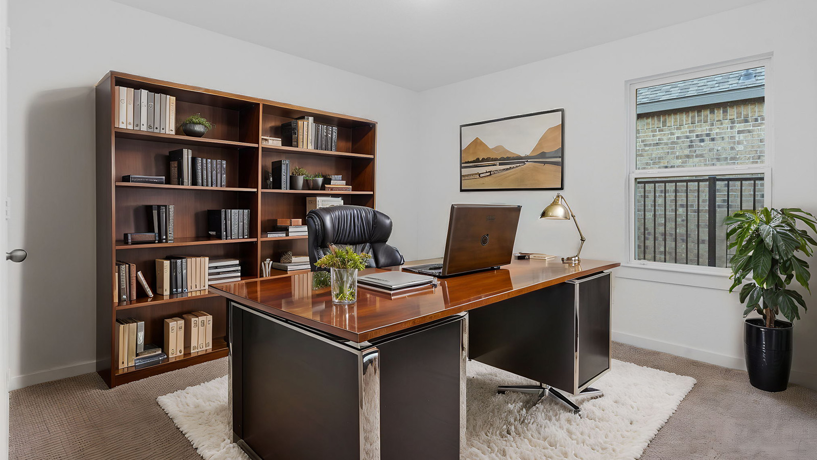 A bedroom shown as an at home office with a bright window allowing natural light to enter.