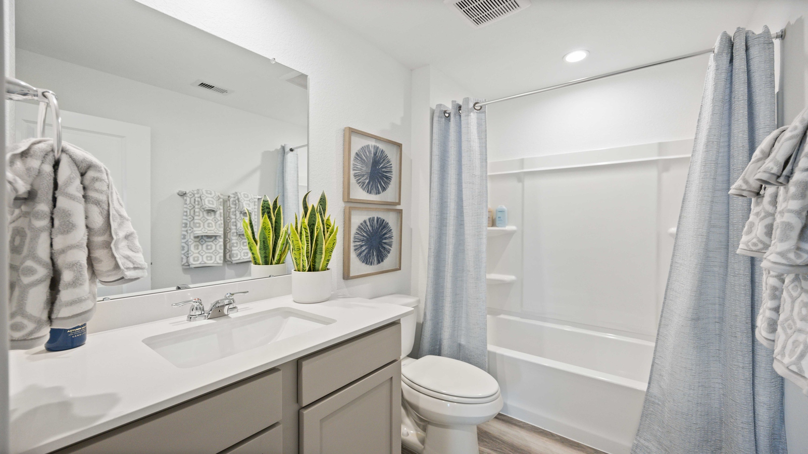 Secondary bathroom vanity with one sink and bathtub shower combo