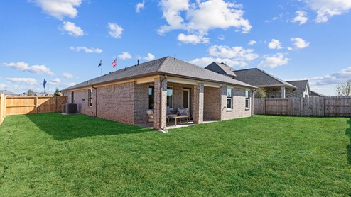 Backyard with sod and a covered back patio