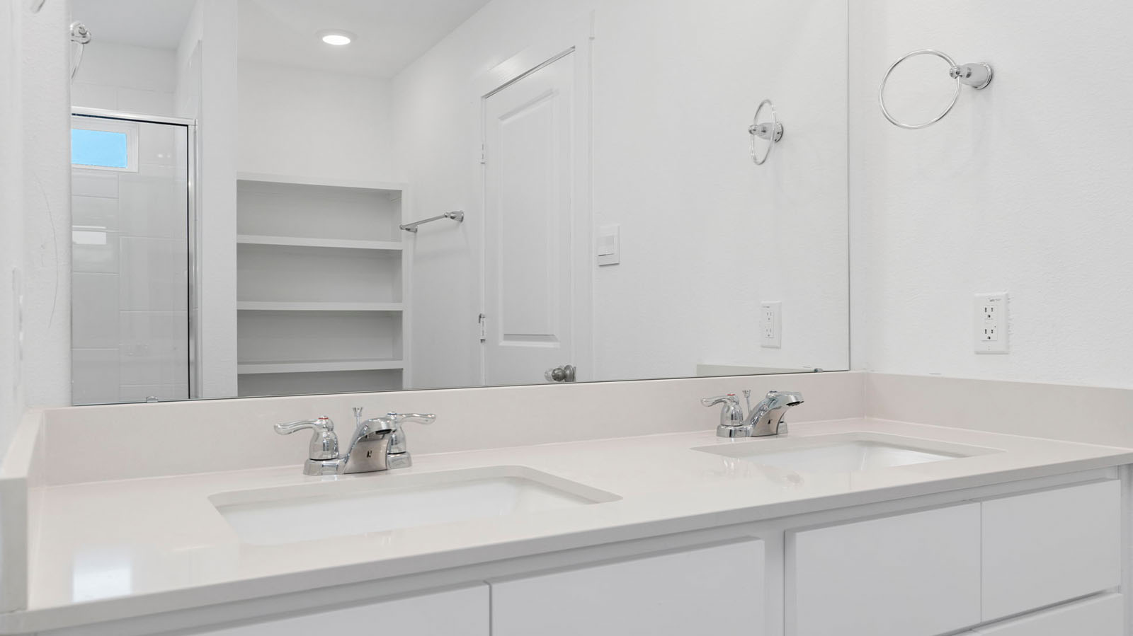 Primary bathroom vanity with two sinks and a large mirror