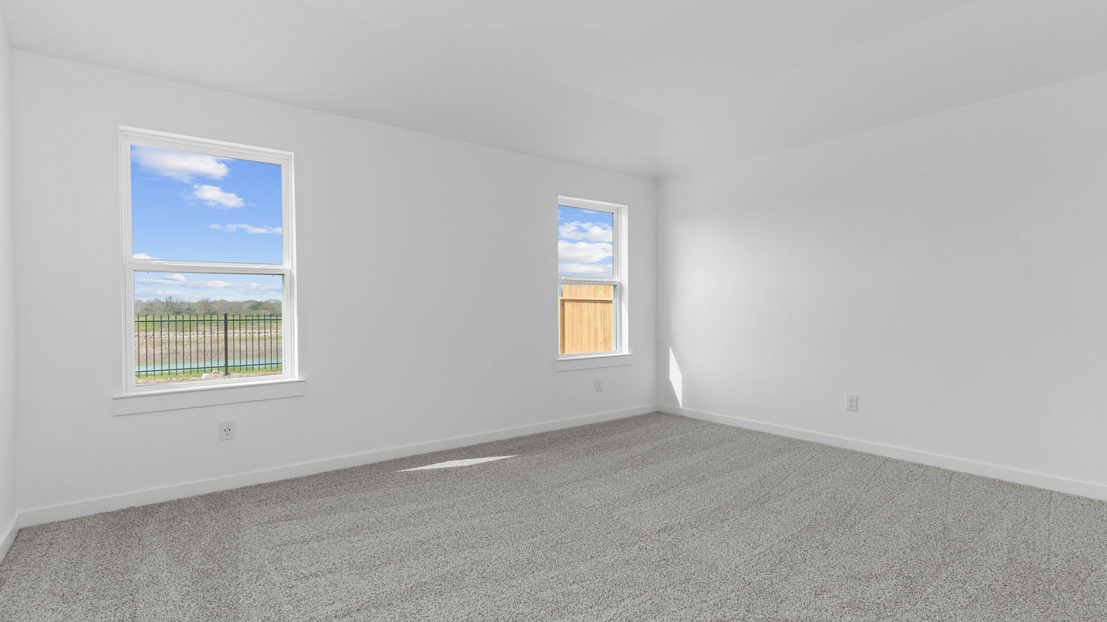 Spacious primary bedroom with two large windows