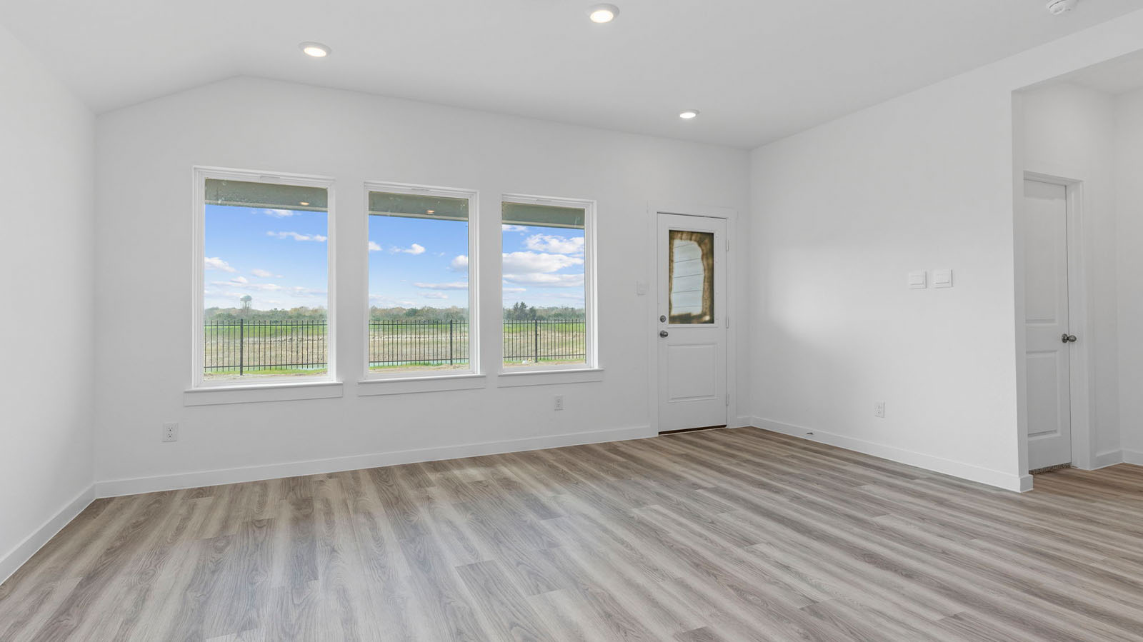 Living room with three large windows and back patio door