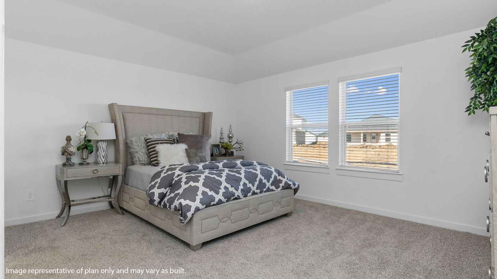 Spacious primary bedroom with two large windows