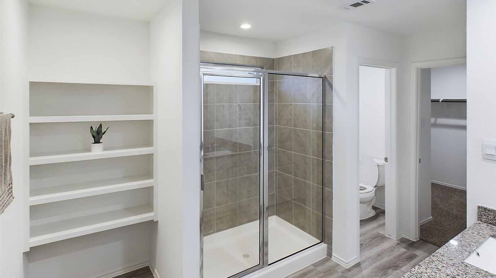 Primary bathroom with open shelving and glass shower