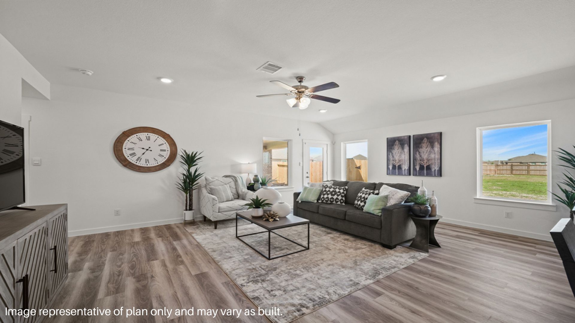 Open concept living room with two large windows and a back patio door