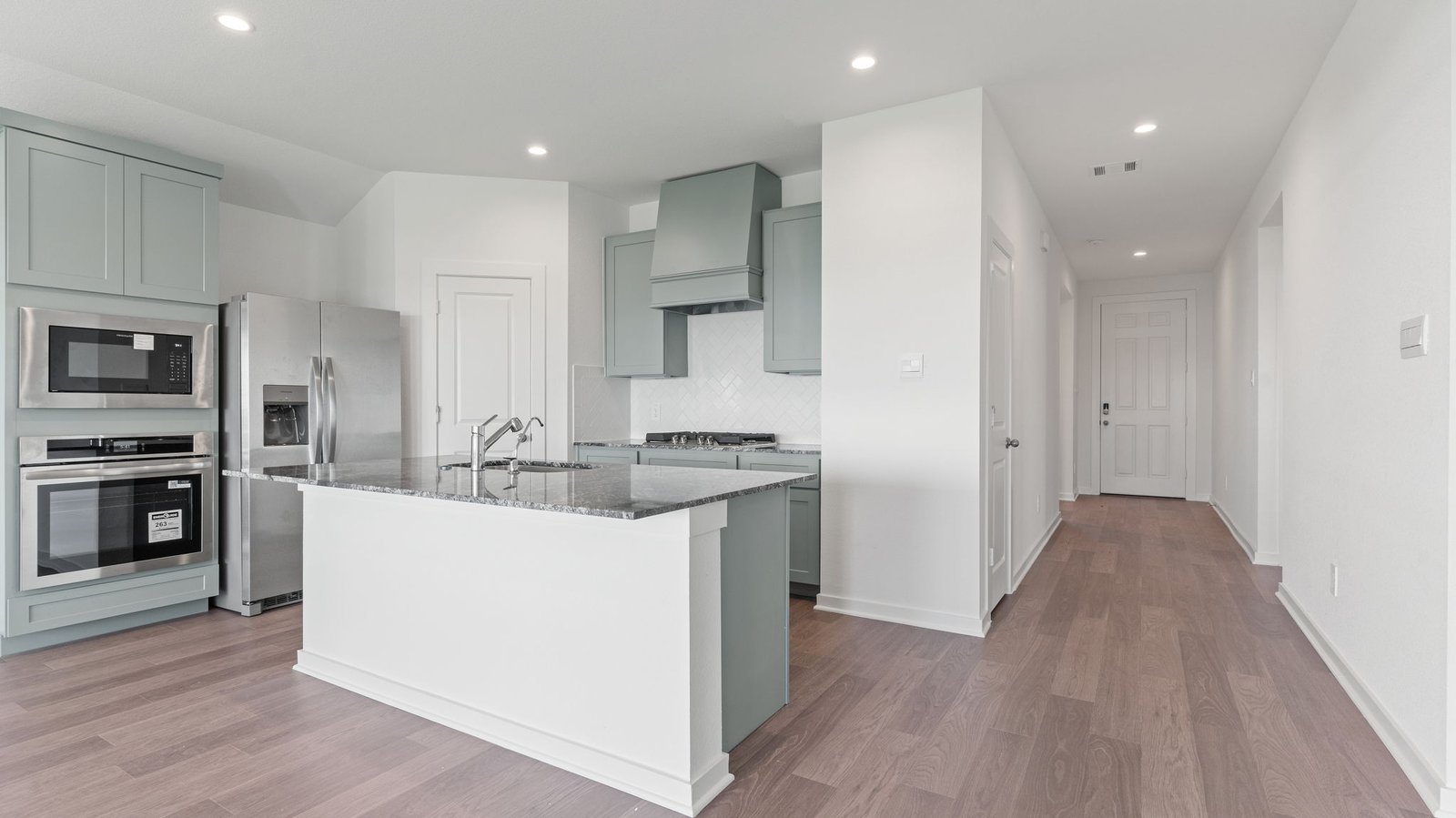 Interior kitchen with center island and light grey cabinets