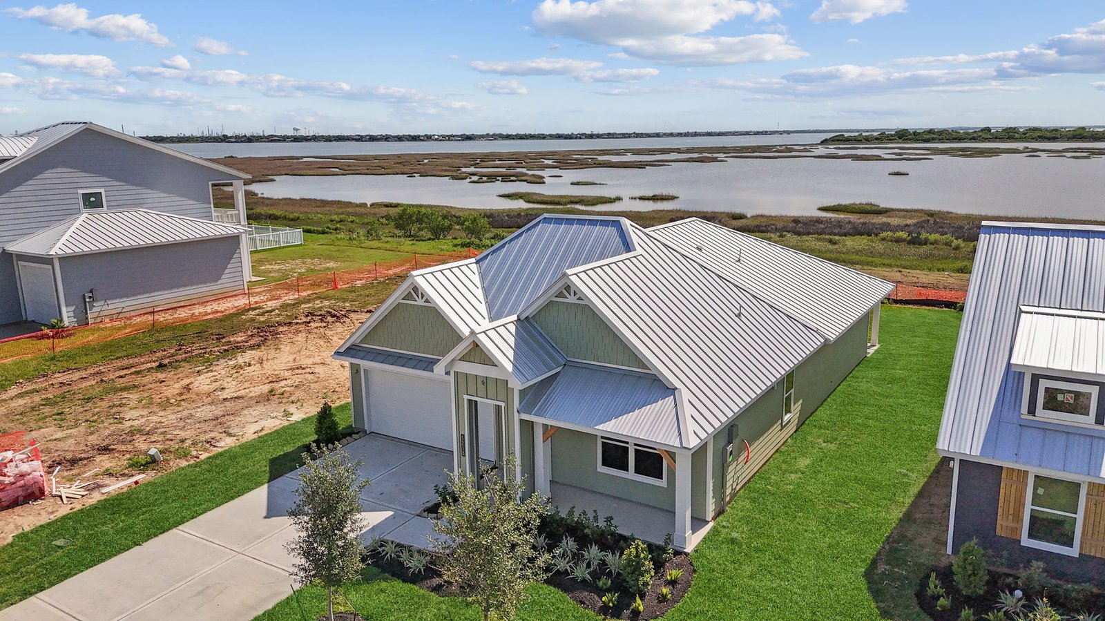 aerial view on one story home with tin roof on water