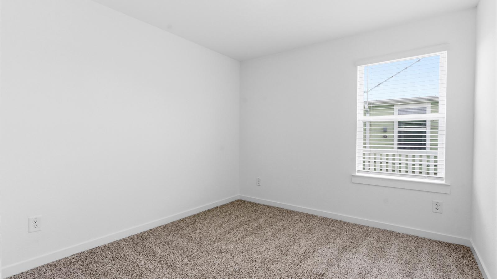 Comfortable guest bedroom featuring neutral-toned walls, carpeted flooring, and a separate closet.