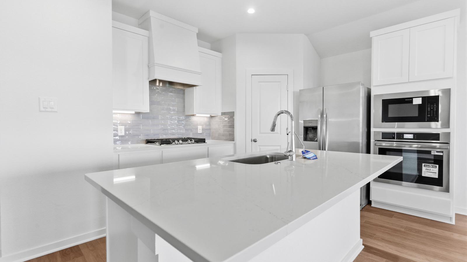 Bright and spacious kitchen with granite countertops, stainless steel appliances, and an island with bar seating.