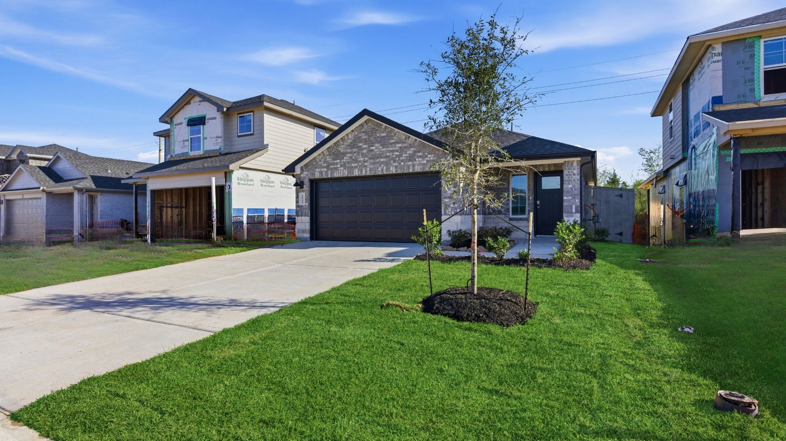 Newly built single story home with traditional architecture, a double garage, and landscaped front yard.