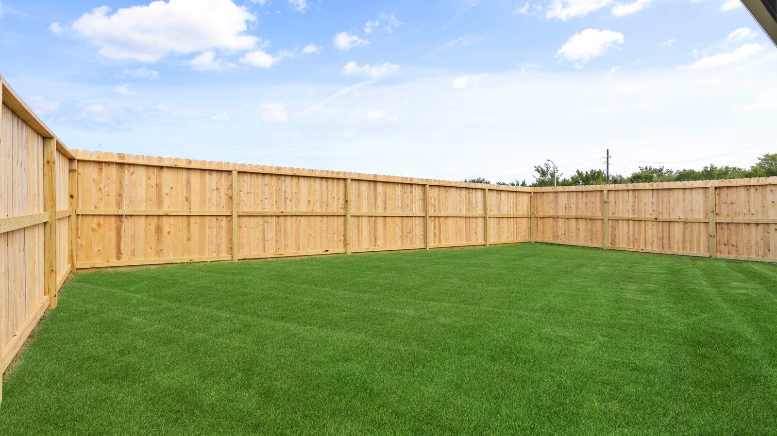 Large fenced-in backyard with a covered patio, perfect for outdoor entertaining.