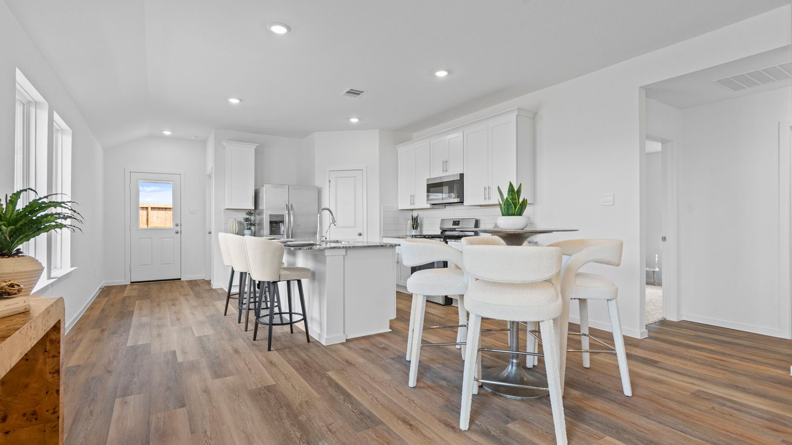 An open concept kitchen with an island with bar seating and access to the living and dining areas.