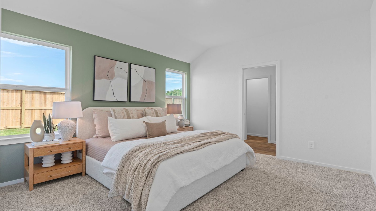 A spacious primary bedroom emphasizing open space and natural lighting with large windows.