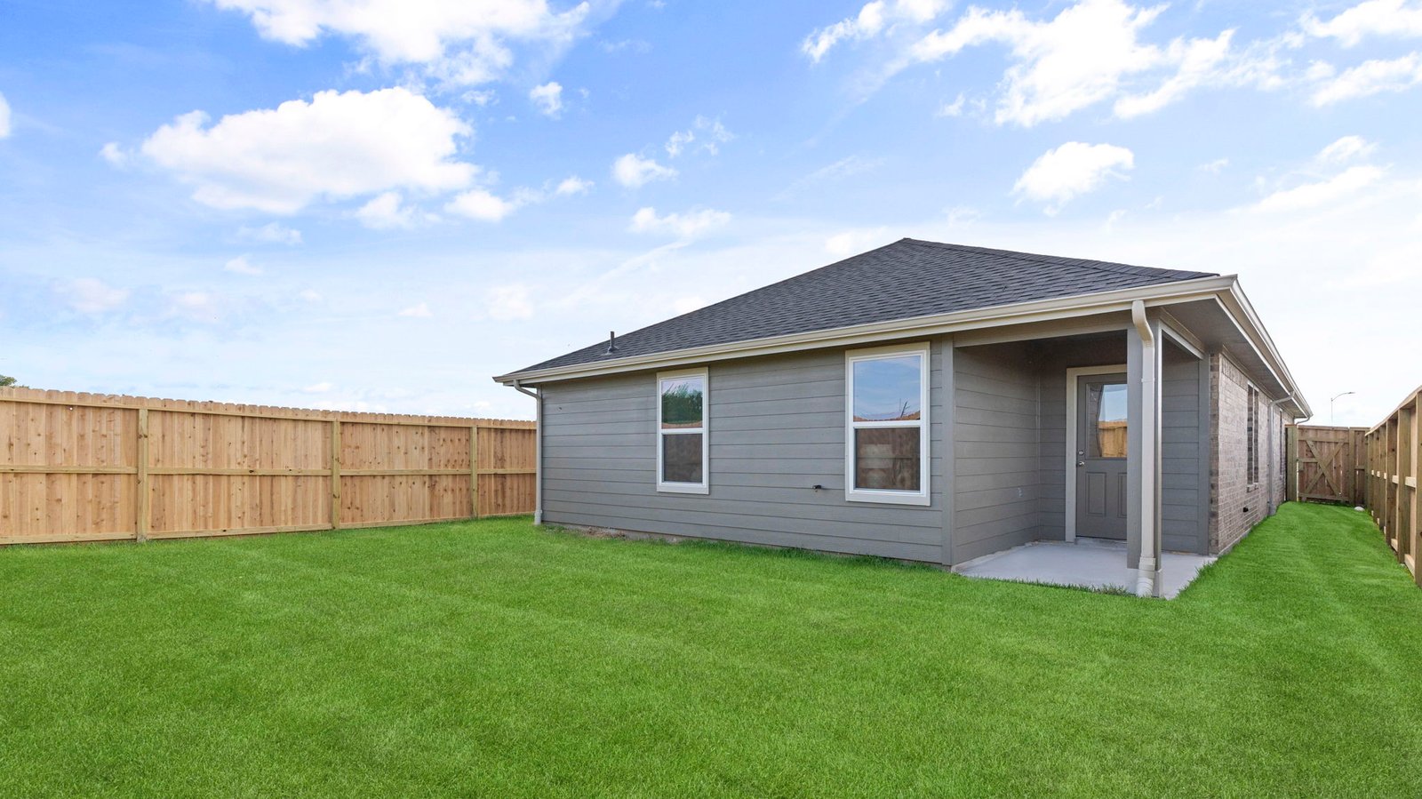Large fenced-in backyard with a covered patio, perfect for outdoor entertaining.