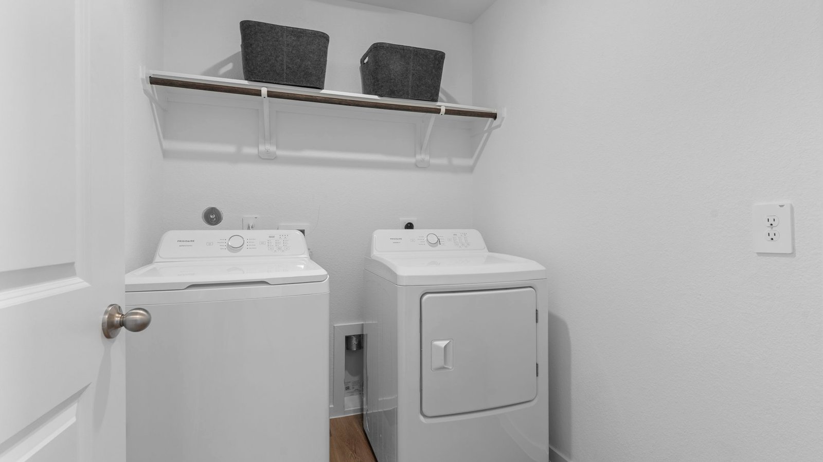 A laundry room featuring a washer and dryer, neatly arranged with ample space for laundry tasks and storage.