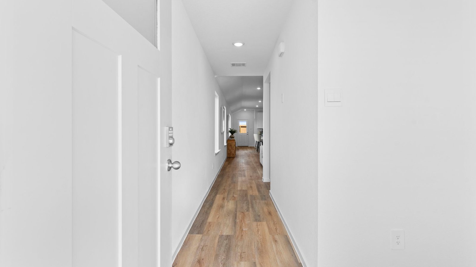 Entry hallway leading to living room and kitchen in the background.