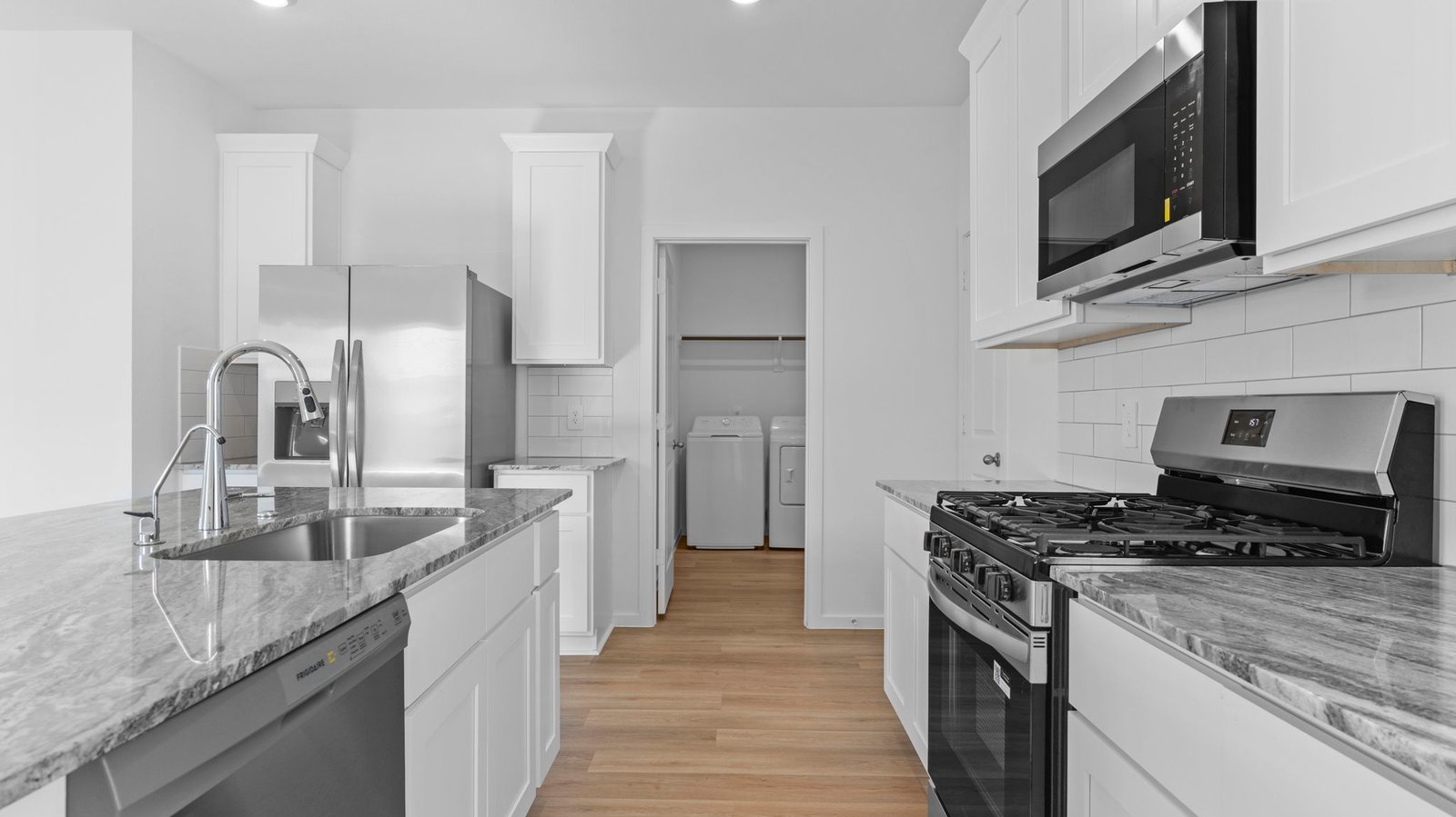 Bright and spacious kitchen with quartz countertops, stainless steel appliances, and an island with bar seating.