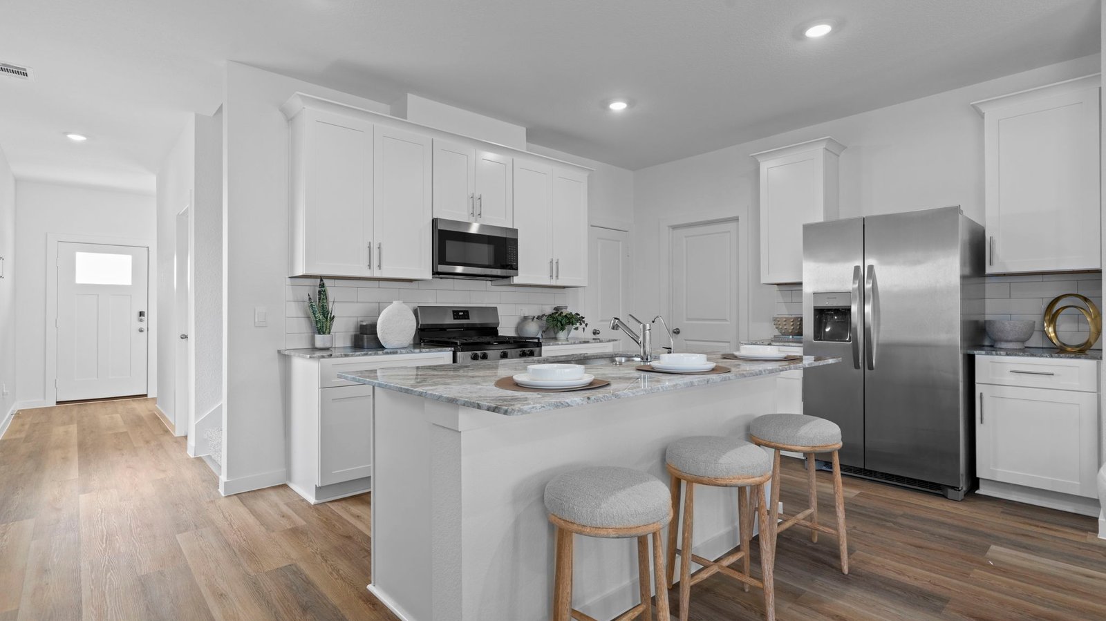 An open concept kitchen with an island with bar seating and access to the living and dining areas.
