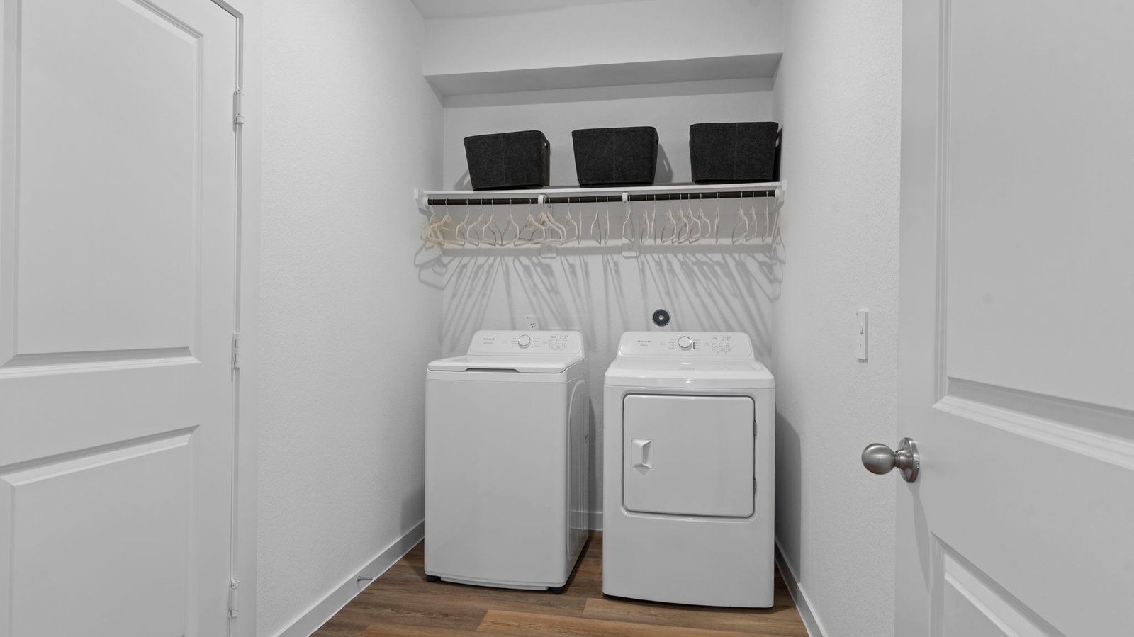 A laundry room featuring a washer and dryer, neatly arranged with ample space for laundry tasks and storage.