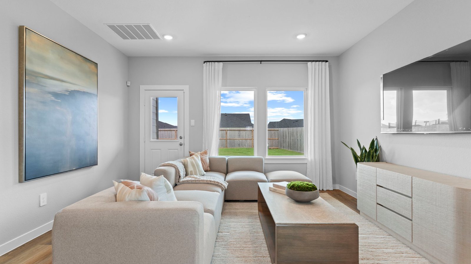 A cozy living room featuring a comfortable couch, a stylish coffee table, and an elegant painting on the wall.