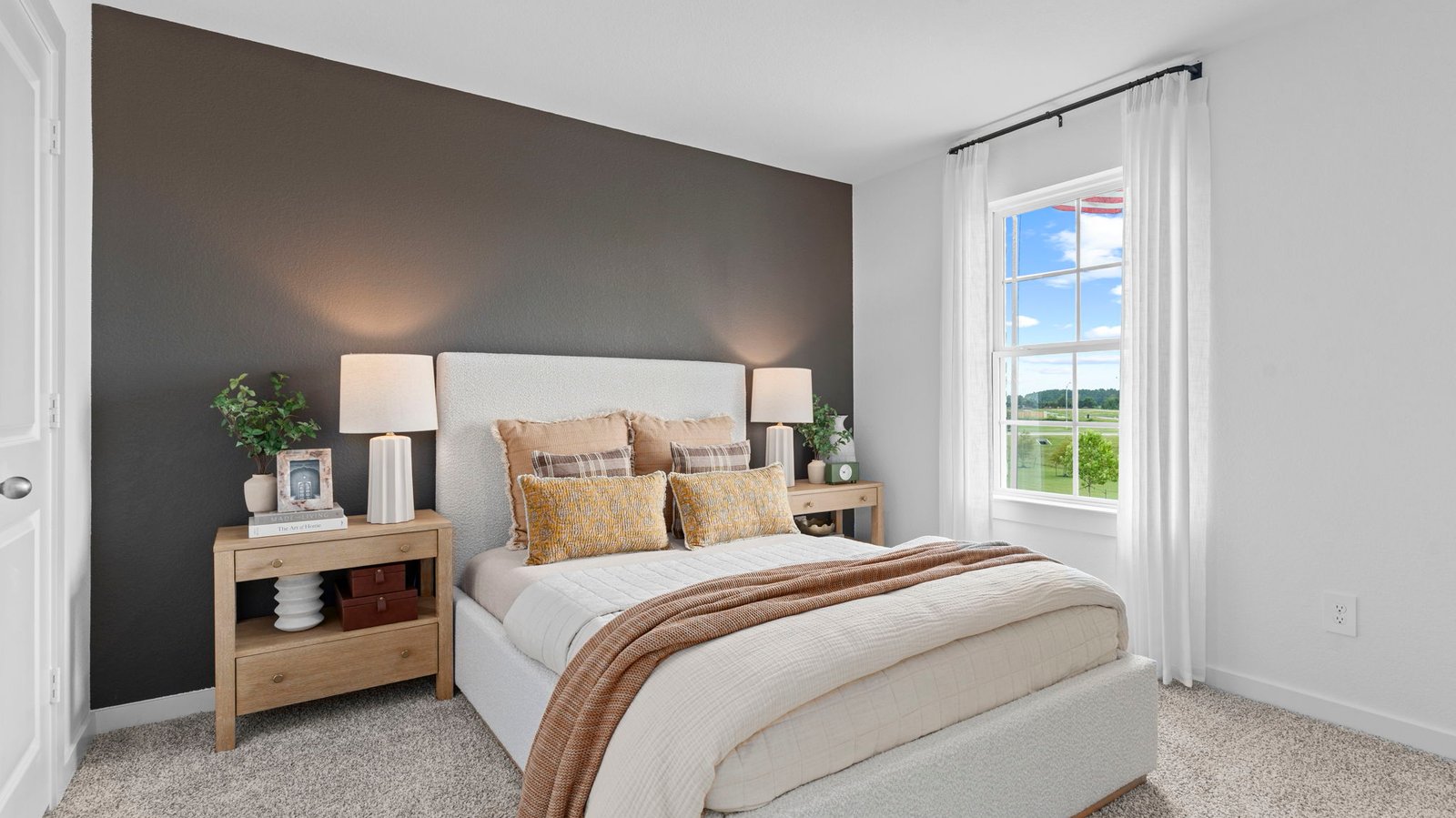 A vibrant bedroom showcasing a neatly made bed, a stylish dresser, and a playful painting that adds charm.