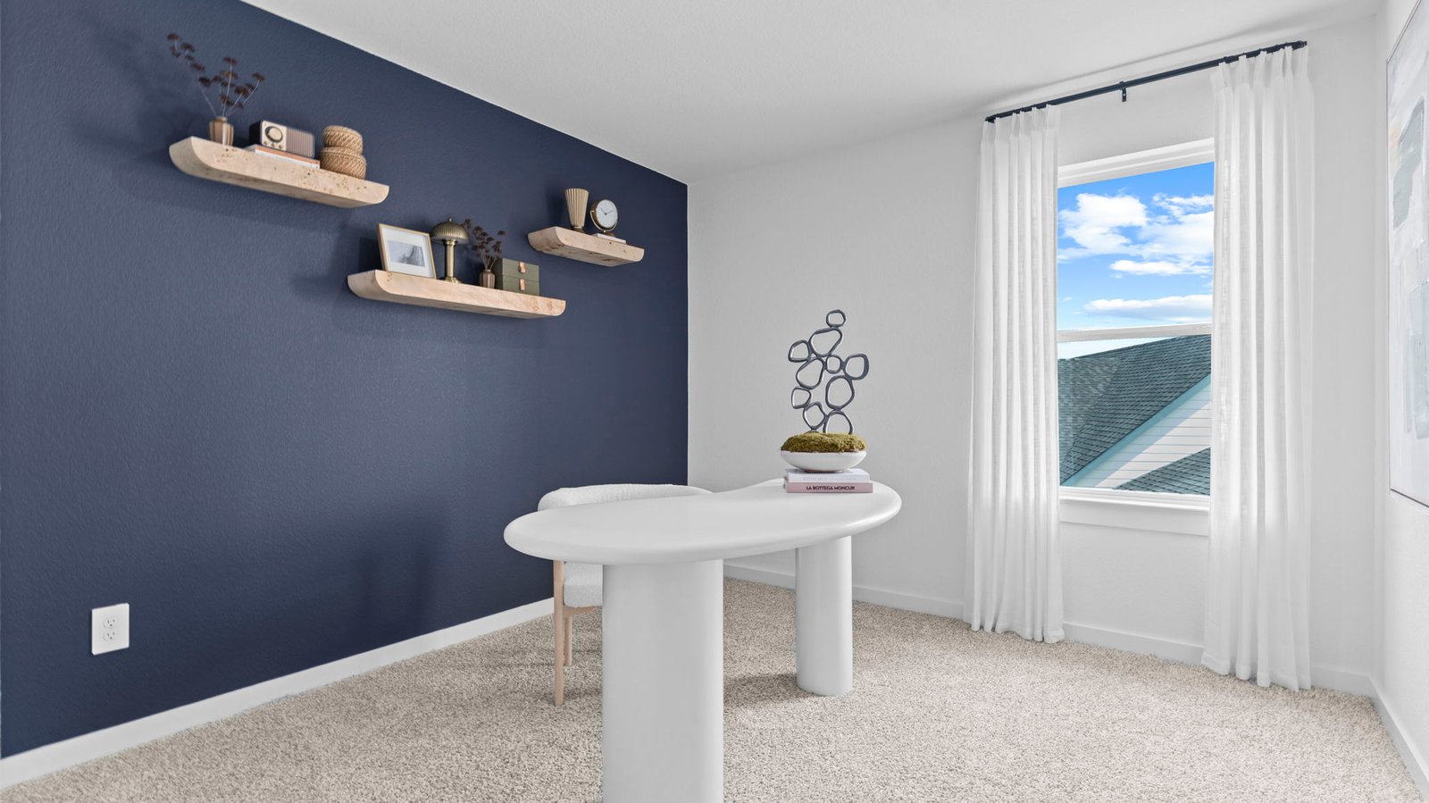 A bedroom shown as an at home office with a bright window allowing natural light to enter.