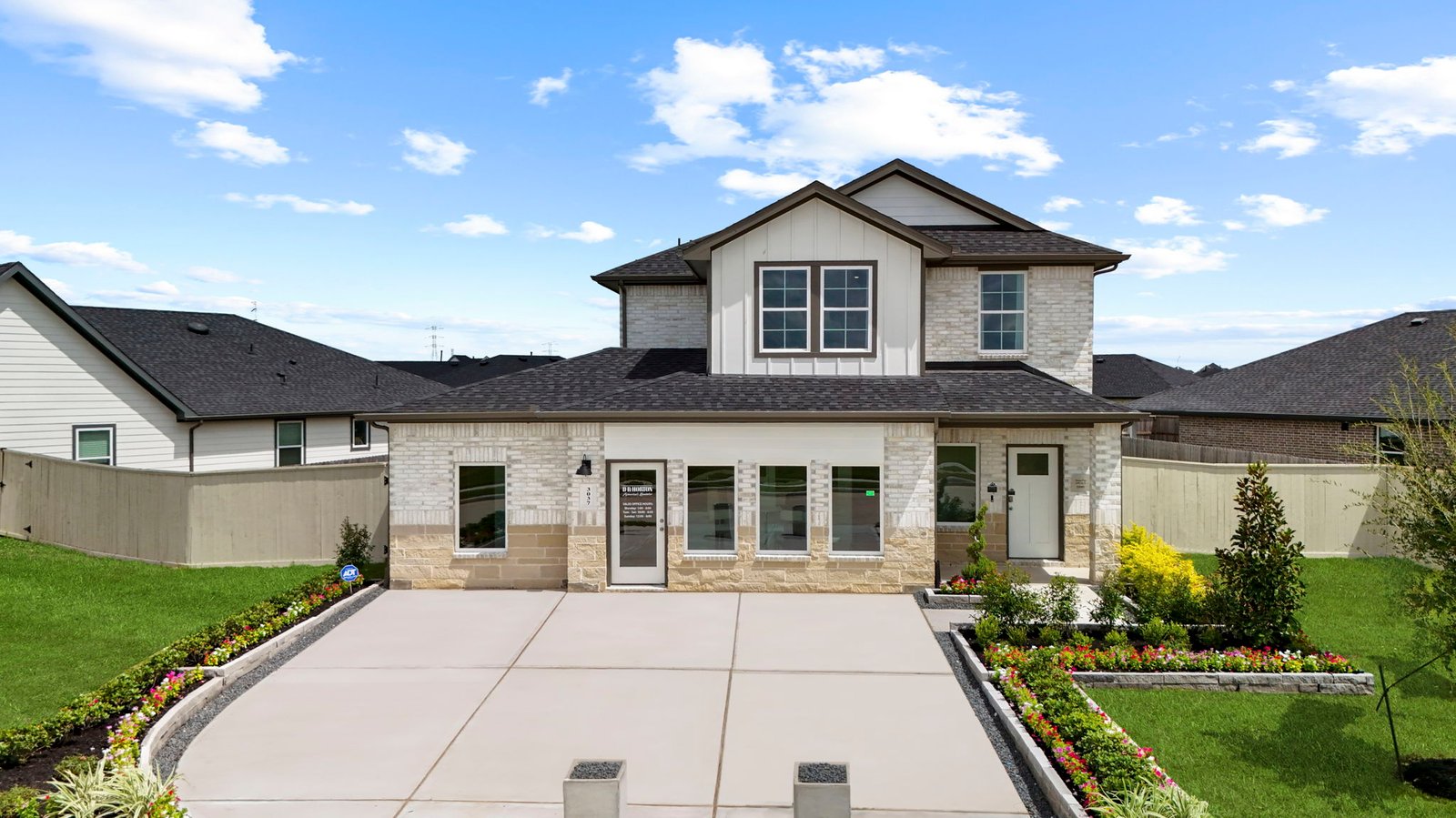 A two-story home with brick and stone exterior with a two-car garage and a well maintained front lawn in league city