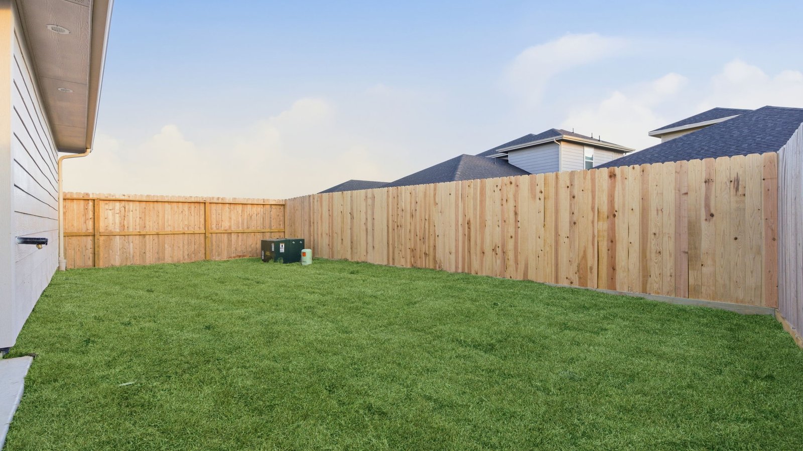 Large fenced-in backyard with a covered patio, perfect for outdoor entertaining.