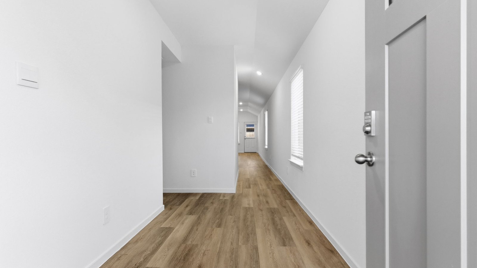 Entry hallway leading to living room and kitchen in the background.