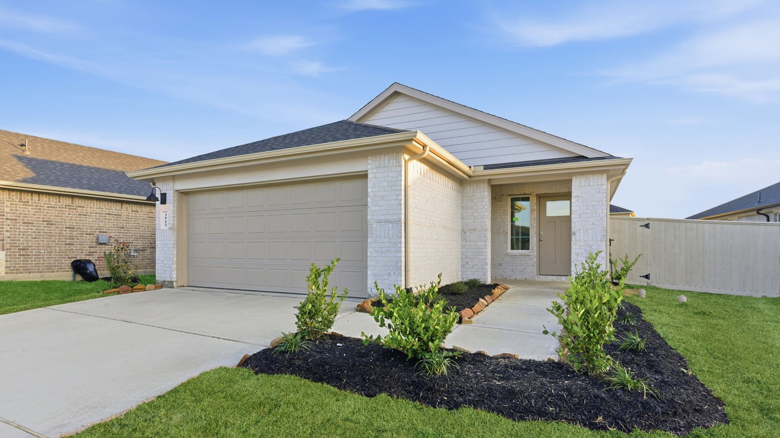 Newly built single story home with traditional architecture, a double garage, and landscaped front yard.