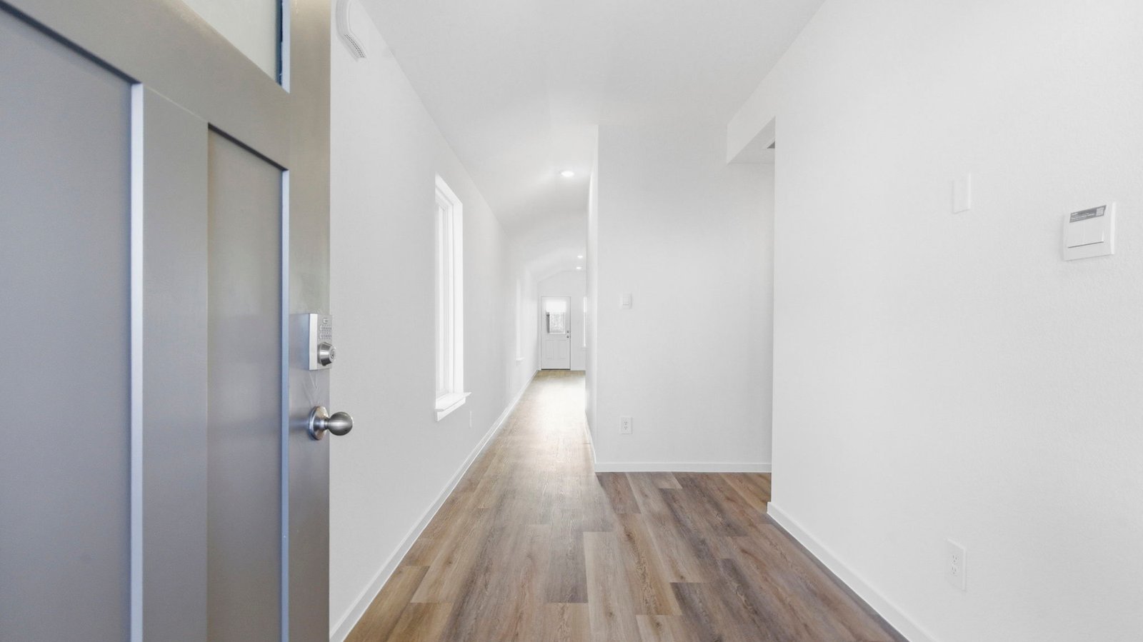 Entry hallway leading to living room and kitchen in the background.