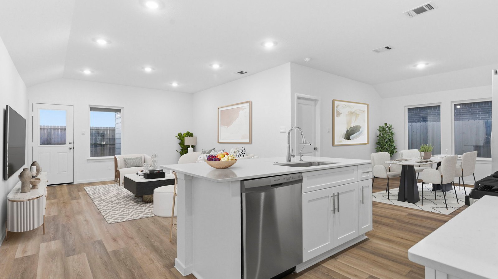 Bright and spacious kitchen with quartz countertops, stainless steel appliances, and an island with bar seating.