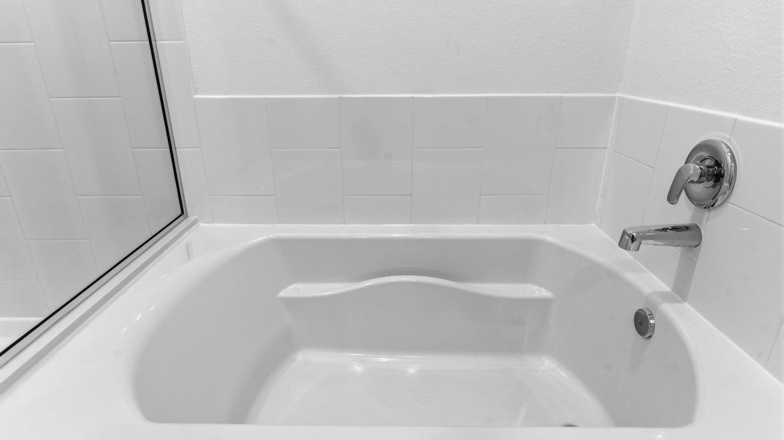 Primary bathroom with a soaking tub, glass-enclosed shower and walk-in closet.