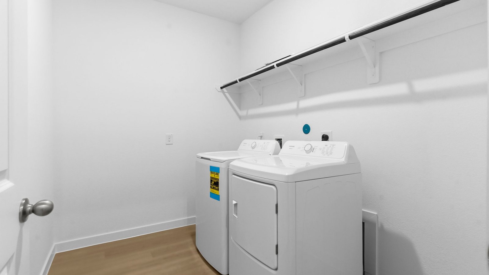 A laundry room featuring a washer and dryer, neatly arranged with ample space for laundry tasks and storage.
