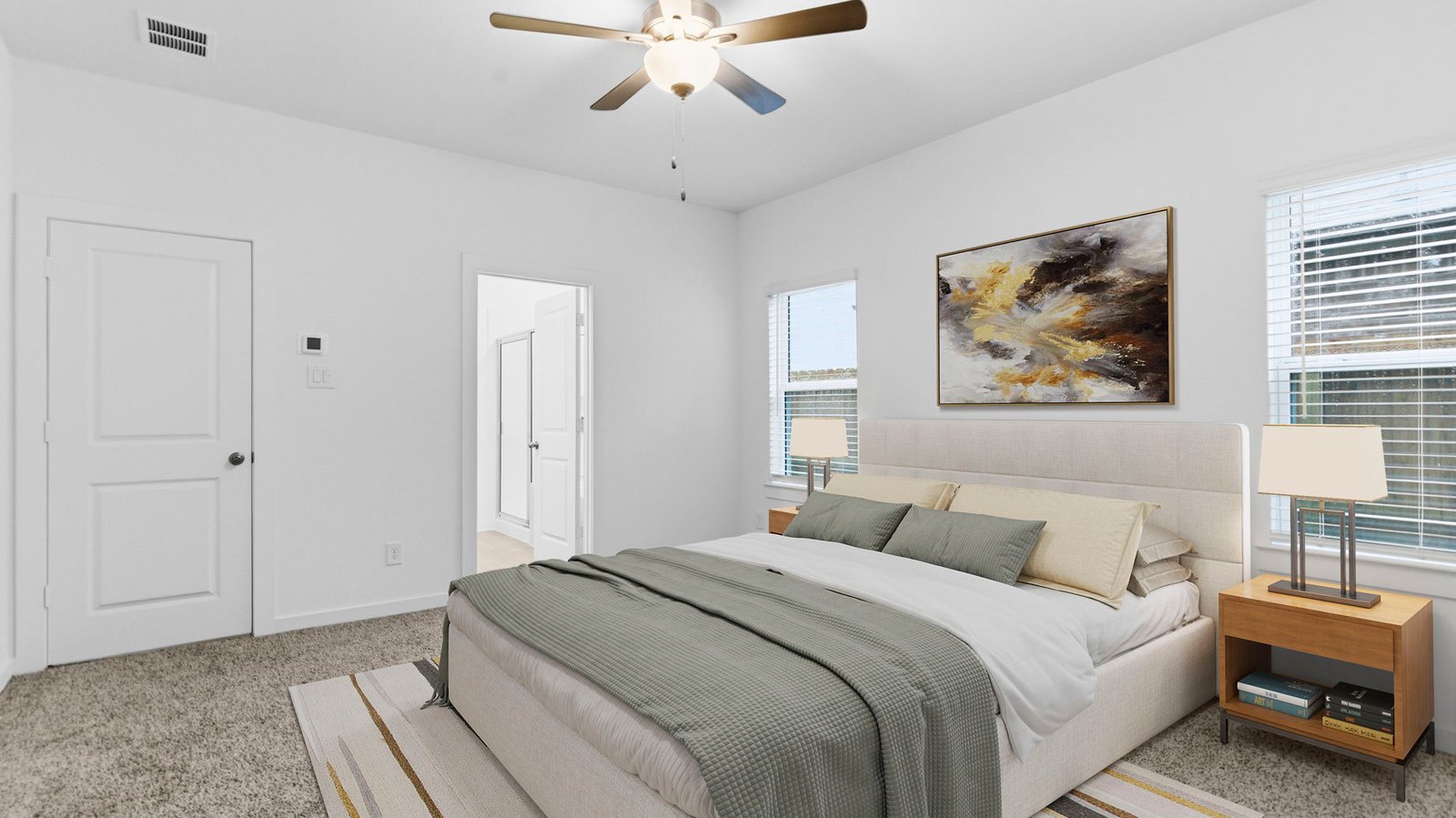 Primary bedroom with ceiling fan, plush carpeting, and a large walk-in closet.