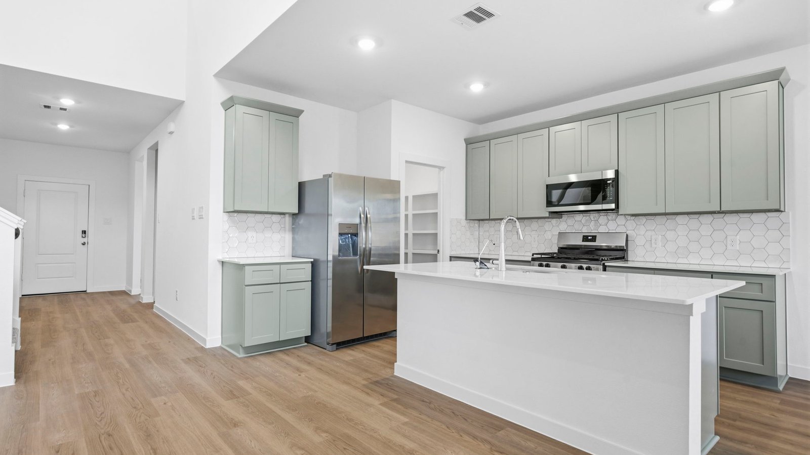 An open concept kitchen with an island with bar seating and access to the living and dining areas.