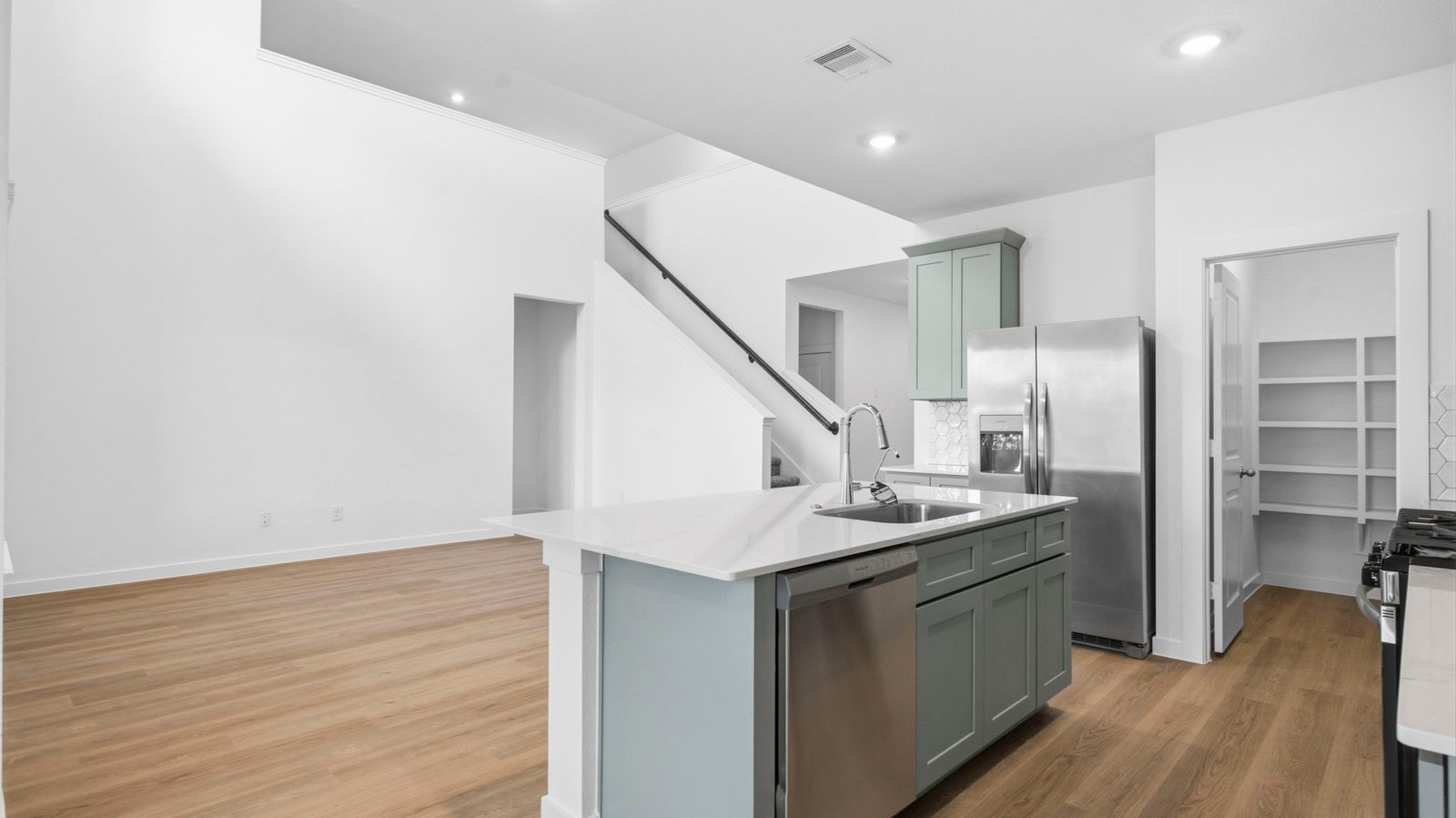 An open concept kitchen with an island with bar seating and access to the living and dining areas.