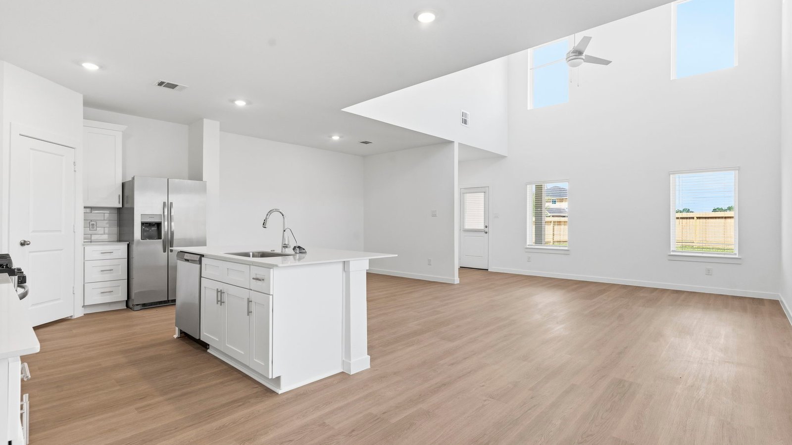 An open concept kitchen with an island with bar seating and access to the living and dining areas.