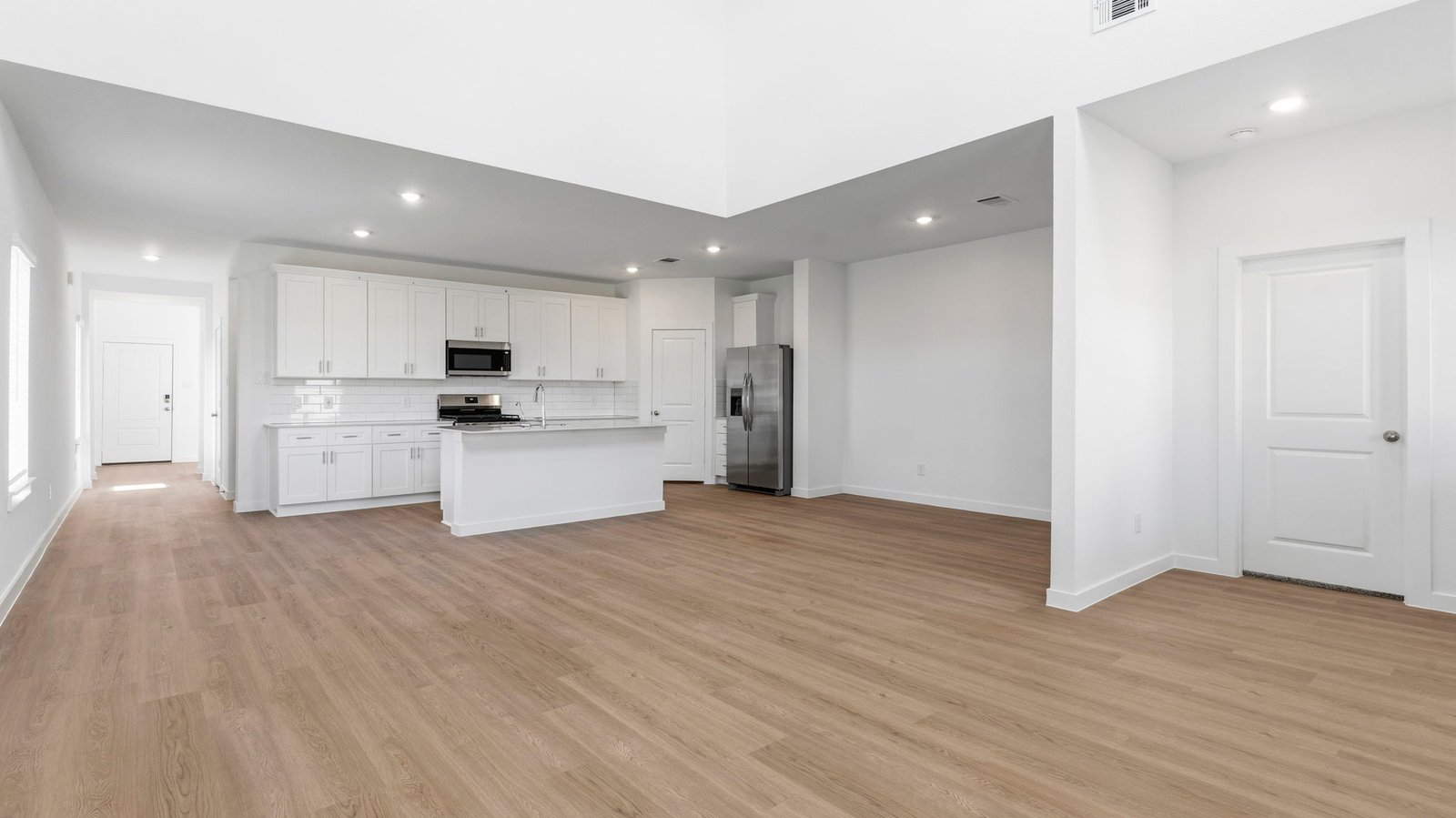 An open concept kitchen with an island with bar seating and access to the living and dining areas.
