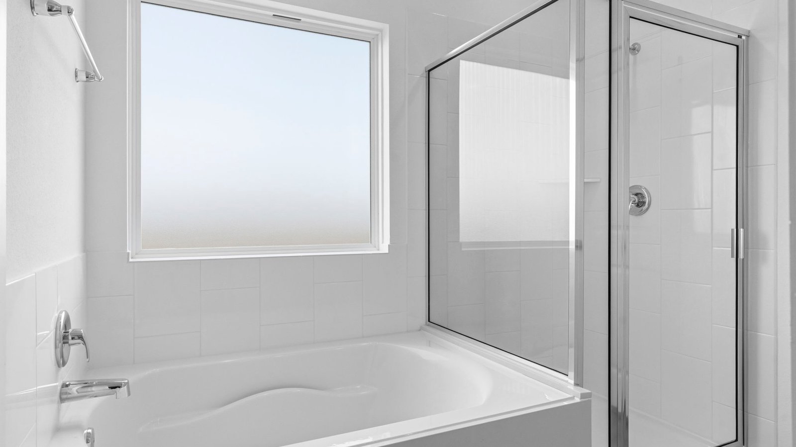 Modern primary bathroom with double vanities, quartz countertops, and a glass-enclosed shower with a walk-in closet.