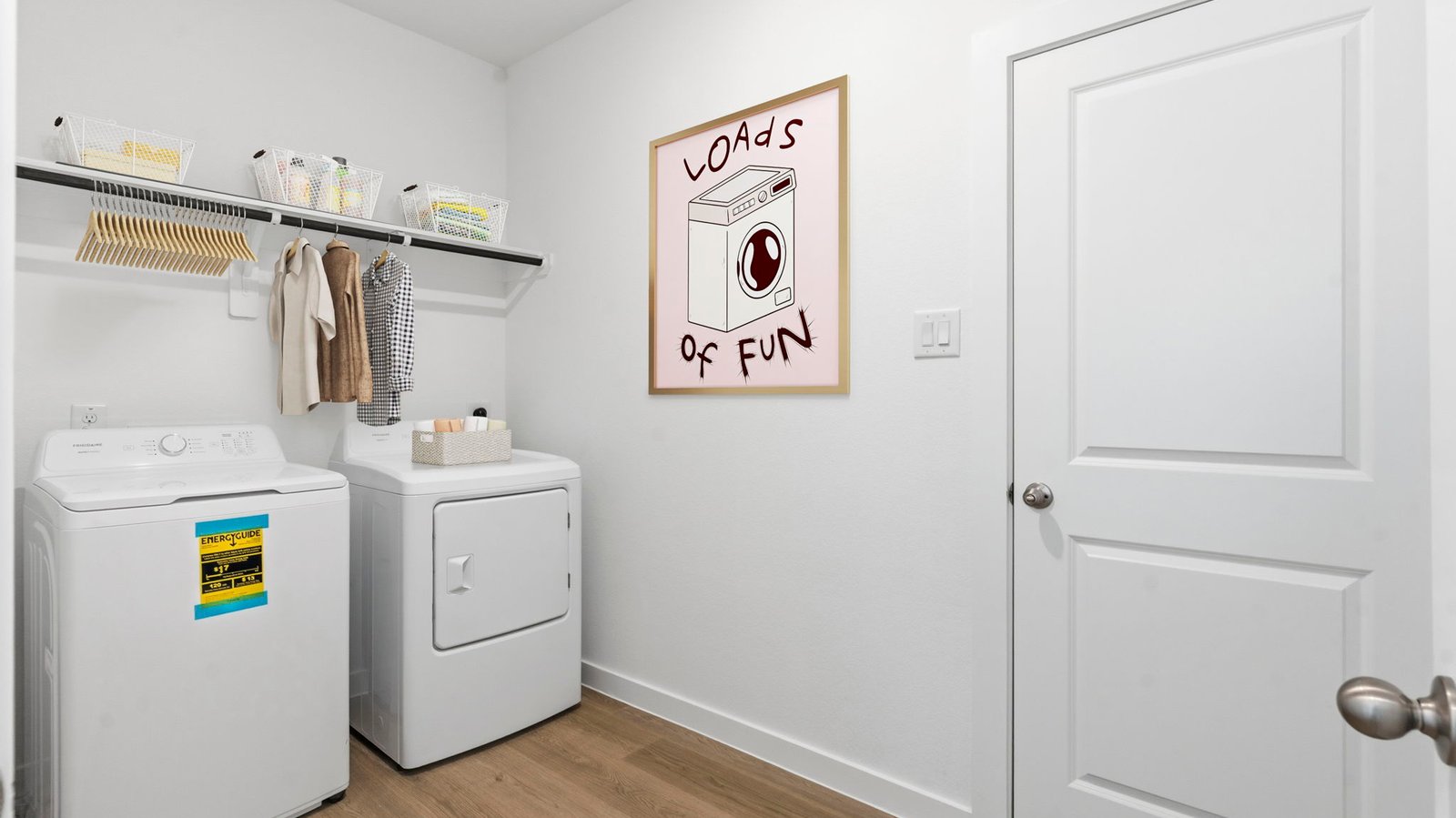 A laundry room featuring a washer and dryer, neatly arranged with ample space for laundry tasks and storage.