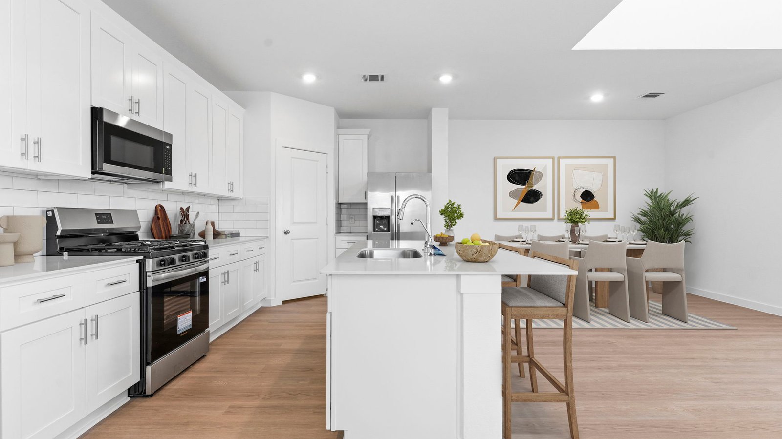 Bright and spacious kitchen with quartz countertops, stainless steel appliances, and an island with bar seating.