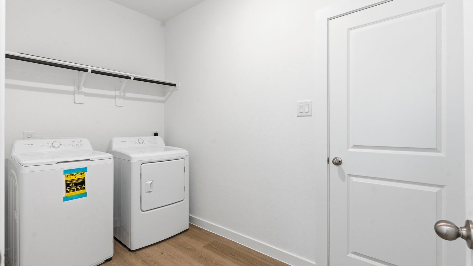 A laundry room featuring a washer and dryer, neatly arranged with ample space for laundry tasks and storage.