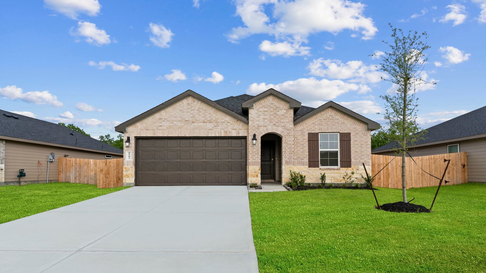 Newly built single story home with traditional architecture, a double garage, and landscaped front yard.